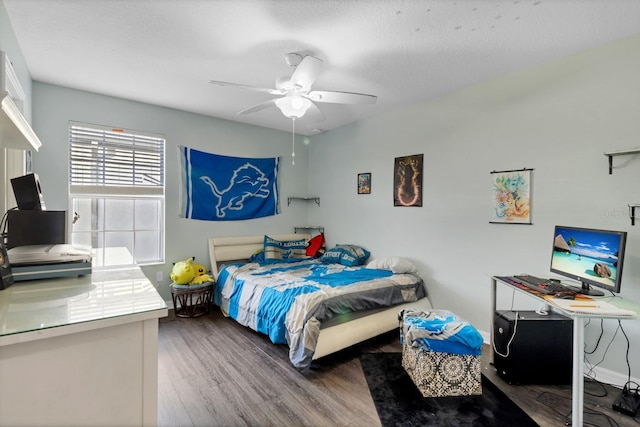 bedroom with ceiling fan, a textured ceiling, and wood finished floors