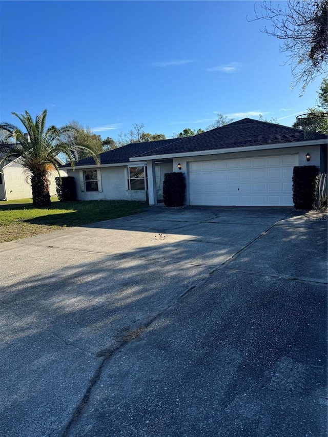 single story home with a garage, concrete driveway, and stucco siding