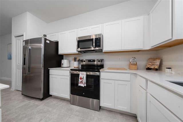 kitchen featuring light countertops, white cabinets, light tile patterned floors, and appliances with stainless steel finishes