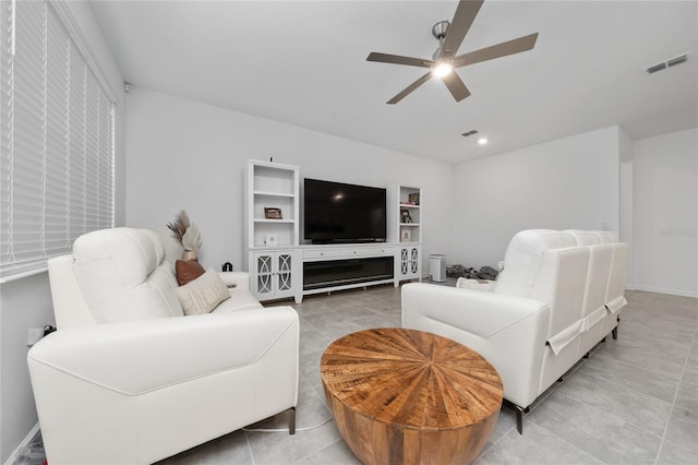 living area featuring light tile patterned flooring, visible vents, and a ceiling fan