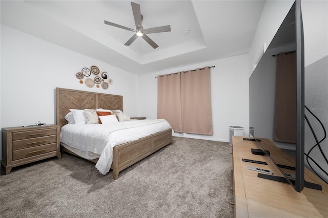 bedroom featuring a tray ceiling, a ceiling fan, and carpet flooring