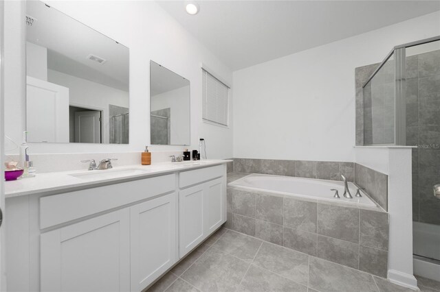 bathroom with a garden tub, a stall shower, visible vents, and a sink