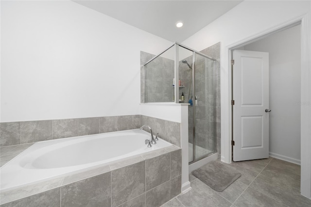 bathroom featuring a bath, tile patterned flooring, and a shower stall