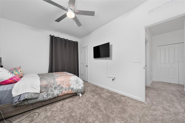 carpeted bedroom with visible vents, baseboards, and a ceiling fan