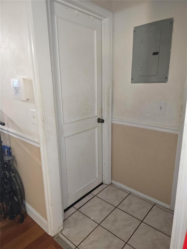 entryway featuring electric panel, baseboards, and light tile patterned floors