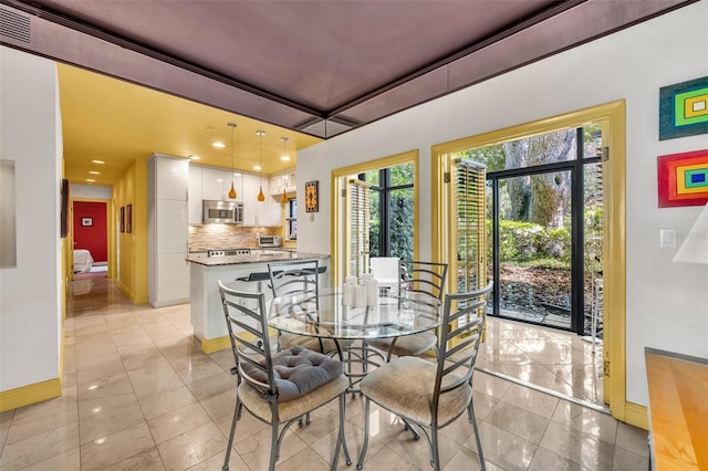 dining area with a toaster, plenty of natural light, visible vents, and baseboards