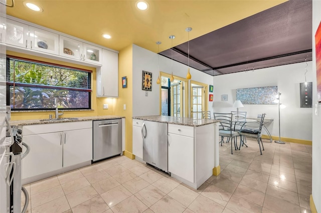 kitchen featuring dishwasher, a peninsula, white cabinetry, fridge, and a sink