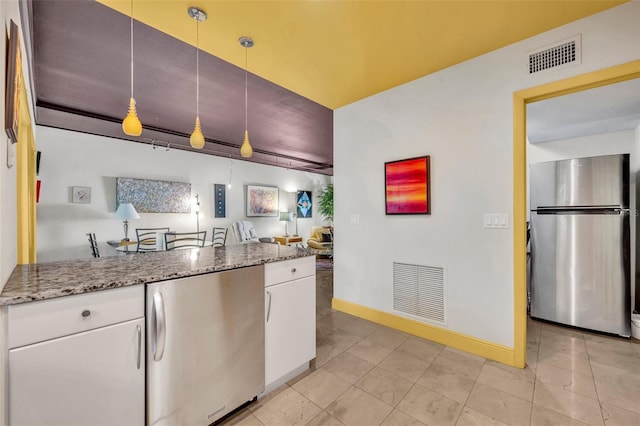 kitchen with white cabinetry, visible vents, stainless steel fridge, and freestanding refrigerator