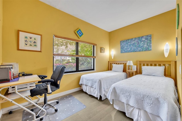 bedroom featuring wood finished floors and baseboards