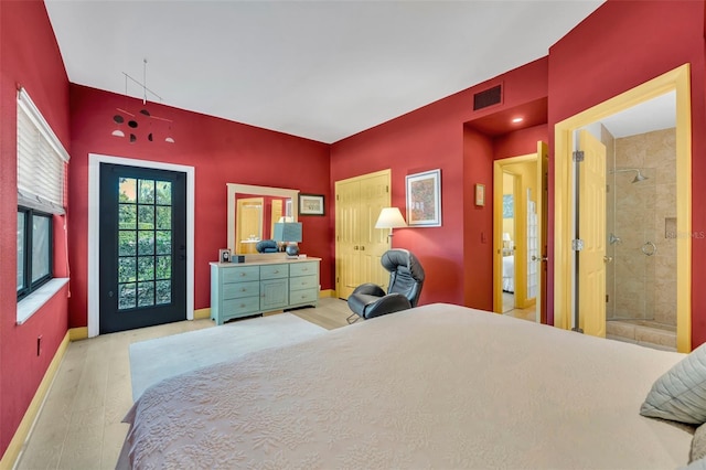 bedroom with visible vents, baseboards, and wood finished floors