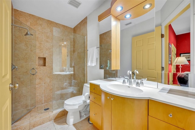 bathroom with vanity, a shower stall, toilet, and visible vents