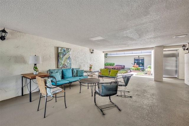 living area with a textured ceiling and a textured wall