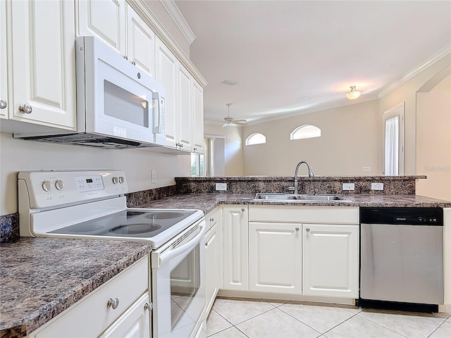 kitchen featuring white appliances, white cabinetry, a sink, and light tile patterned floors