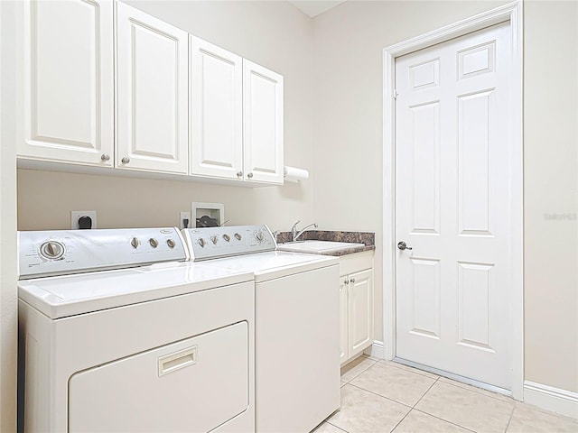 laundry room featuring cabinet space, washing machine and dryer, light tile patterned flooring, a sink, and baseboards