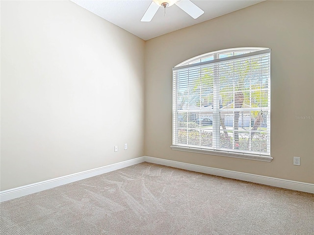 unfurnished room with light carpet, ceiling fan, and baseboards