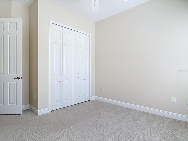 unfurnished bedroom featuring a closet, carpet, and baseboards