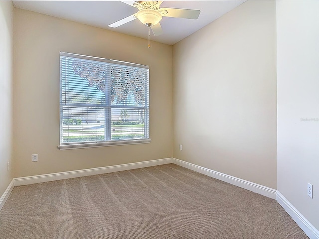 spare room with a ceiling fan, baseboards, and carpet flooring