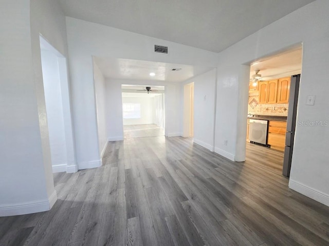 corridor with visible vents, baseboards, and wood finished floors