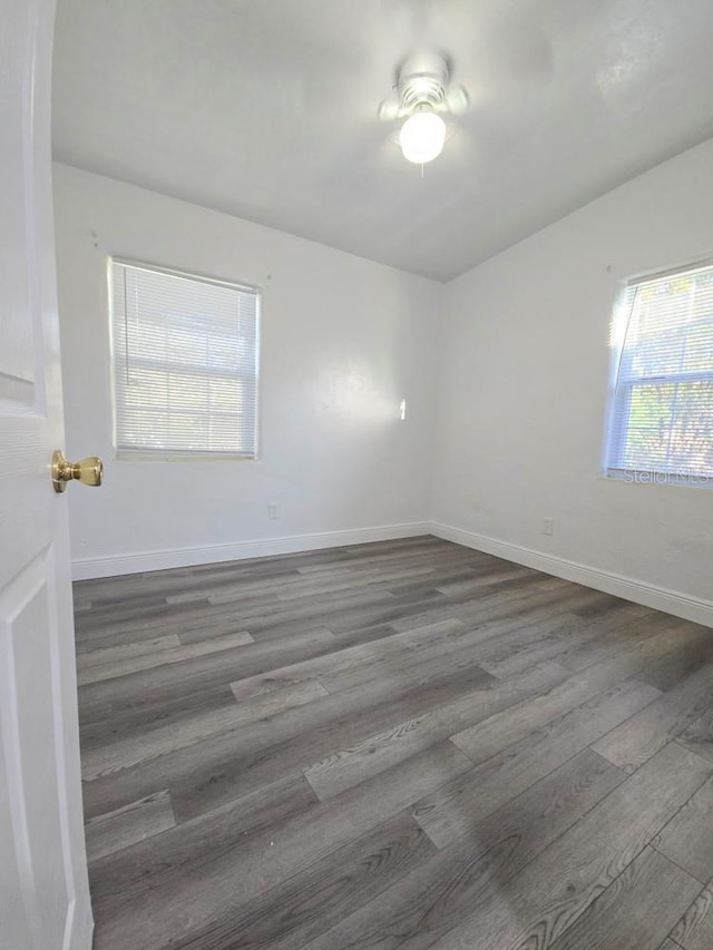 spare room with baseboards, a ceiling fan, and wood finished floors