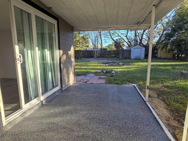 view of patio with a storage shed, an outbuilding, and a fenced backyard