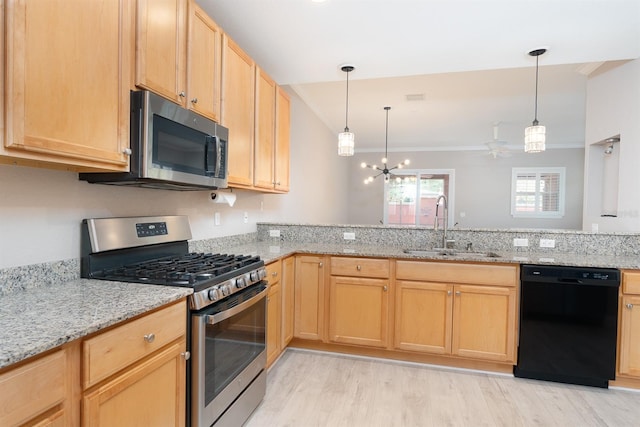 kitchen with light brown cabinets, light stone counters, stainless steel appliances, and a sink