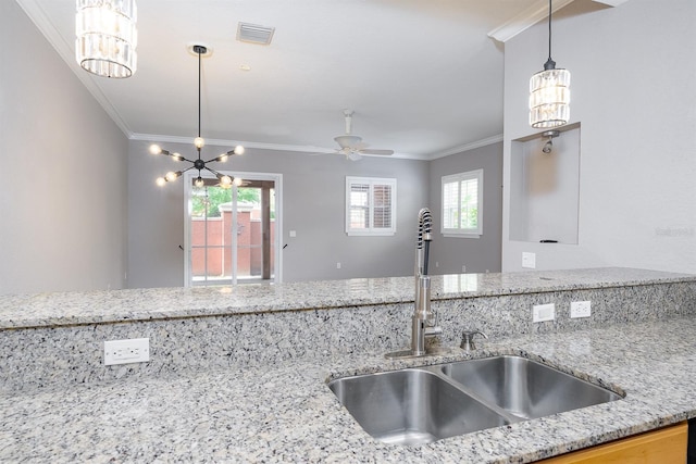 kitchen featuring ornamental molding, a wealth of natural light, visible vents, and a sink