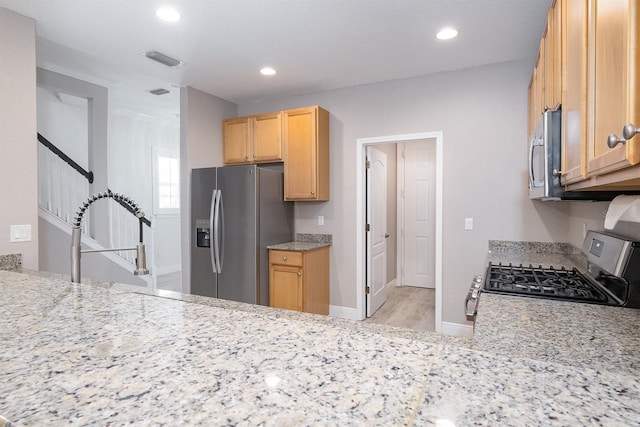 kitchen with recessed lighting, stainless steel appliances, visible vents, baseboards, and light stone countertops