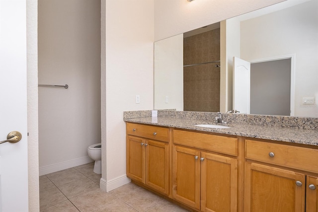 bathroom featuring baseboards, vanity, toilet, and tile patterned floors