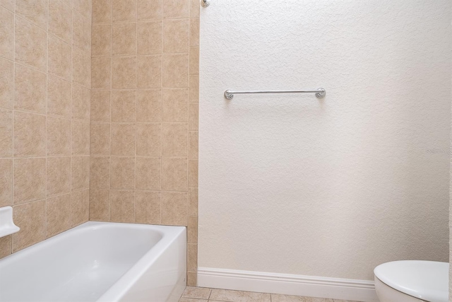 bathroom with baseboards, toilet, a tub, tile patterned floors, and walk in shower