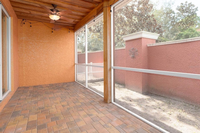 unfurnished sunroom with wood ceiling and ceiling fan