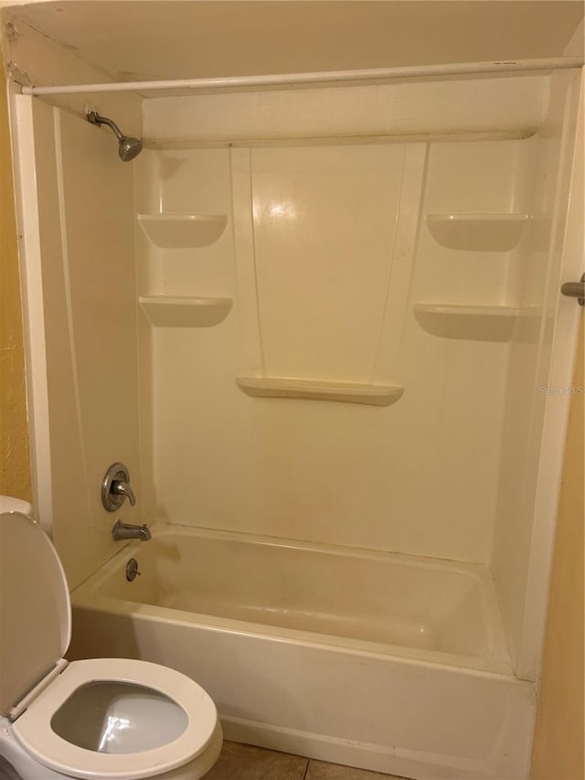 bathroom featuring tile patterned flooring, shower / bathing tub combination, and toilet