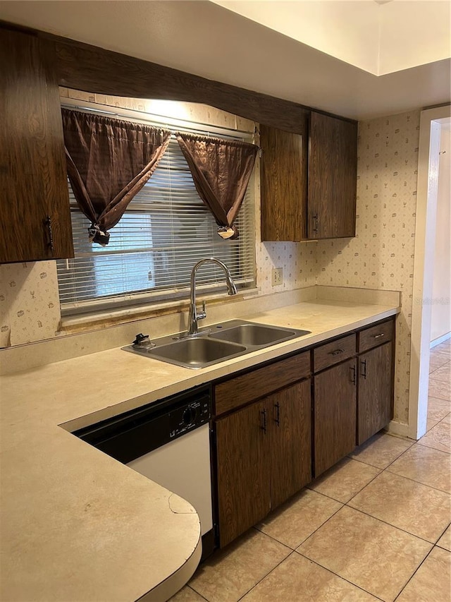 kitchen featuring light countertops, dark brown cabinets, and a sink