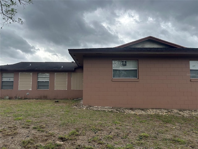 view of side of property featuring a yard and concrete block siding