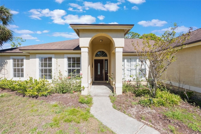 property entrance with stucco siding and french doors