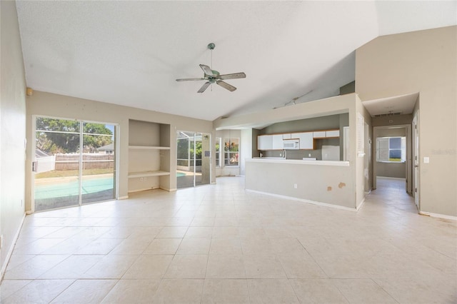 unfurnished living room with built in shelves, high vaulted ceiling, light tile patterned floors, baseboards, and ceiling fan