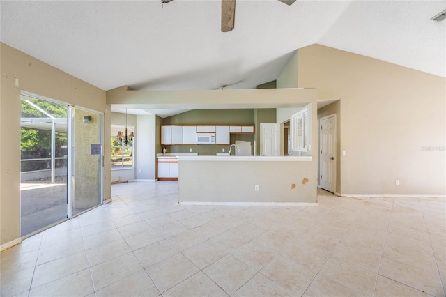 unfurnished living room featuring visible vents, ceiling fan, baseboards, lofted ceiling, and light tile patterned flooring