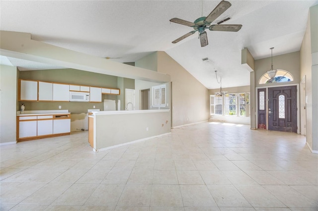 unfurnished living room featuring light tile patterned flooring, ceiling fan with notable chandelier, baseboards, and high vaulted ceiling