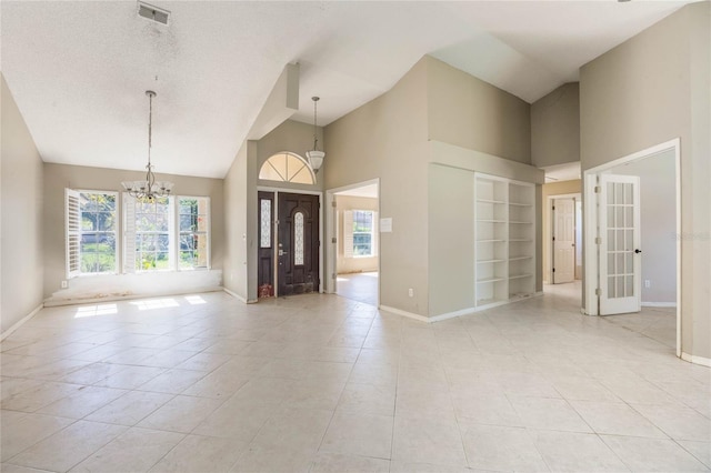 entrance foyer featuring an inviting chandelier, baseboards, visible vents, and a wealth of natural light