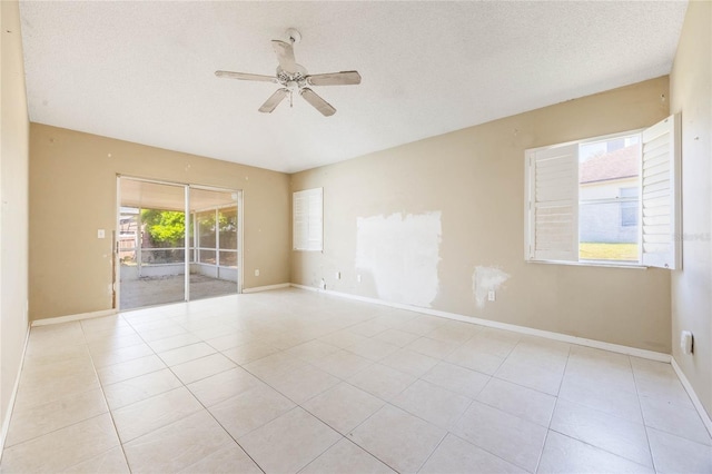 tiled spare room featuring a ceiling fan, baseboards, and a textured ceiling