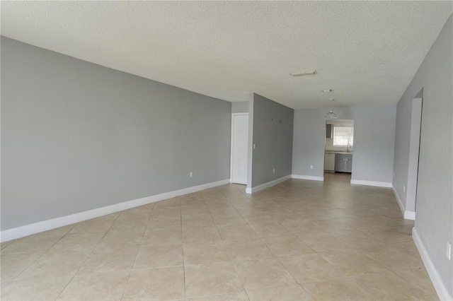 empty room featuring baseboards and a textured ceiling