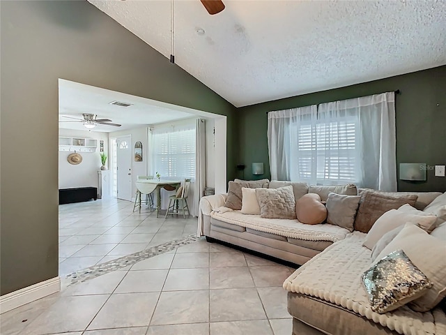 living room featuring ceiling fan, vaulted ceiling, light tile patterned flooring, and visible vents