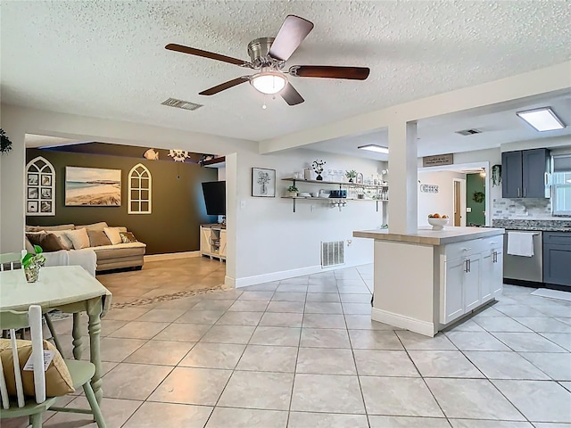 kitchen featuring dishwasher, open floor plan, light tile patterned flooring, and visible vents