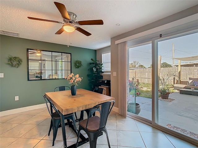 dining space with baseboards, visible vents, a textured ceiling, and light tile patterned flooring