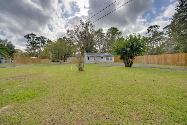 view of yard featuring an outdoor structure and fence