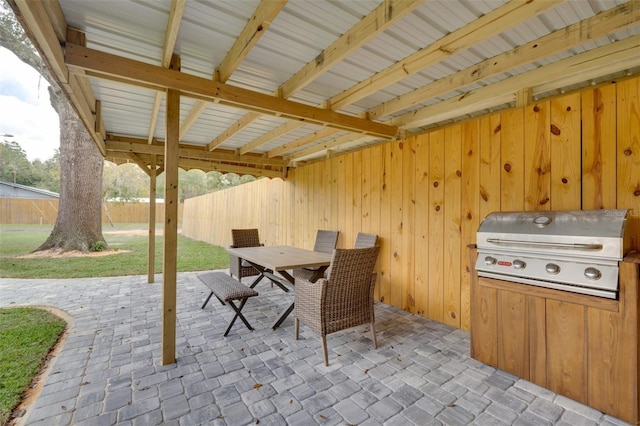 view of patio with an outdoor kitchen, fence, grilling area, and outdoor dining space