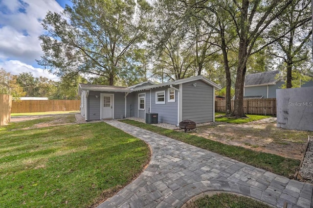 view of front facade with a front lawn, cooling unit, and fence