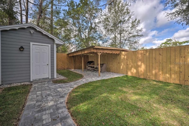 view of yard with a patio, an outdoor structure, and a fenced backyard