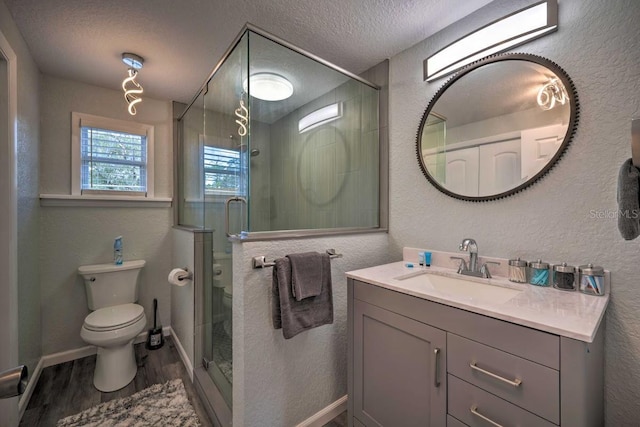 bathroom with toilet, a shower stall, a textured ceiling, and wood finished floors