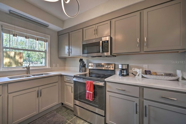 kitchen featuring stainless steel appliances, light countertops, and gray cabinetry