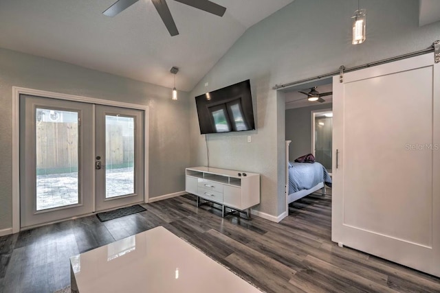 interior space with french doors, a barn door, dark wood-type flooring, a ceiling fan, and vaulted ceiling